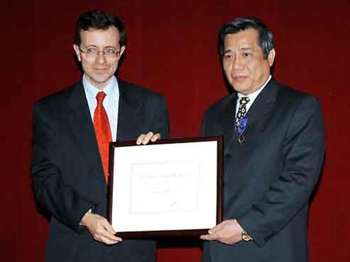 Phó tổng Vụ trưởng Hợp tác quốc tế và Phát triển của Bộ Ngoại giao Pháp (trái) trao giải thưởng Cành cọ Hàn Lâm cho GSTSKH Vũ Minh Giang. (Ảnh: Di Giorgio) Và trao Cành cọ vàng cho GS Đỗ Trọng Nhuận (phải). (Ảnh: Di Giorgio)