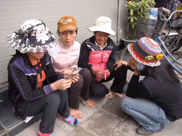 Chị Đỗ Thị Oanh (thứ hai từ phải sang) chia tiền cho chị em đi làm cùng. Ảnh: Trường Phong.