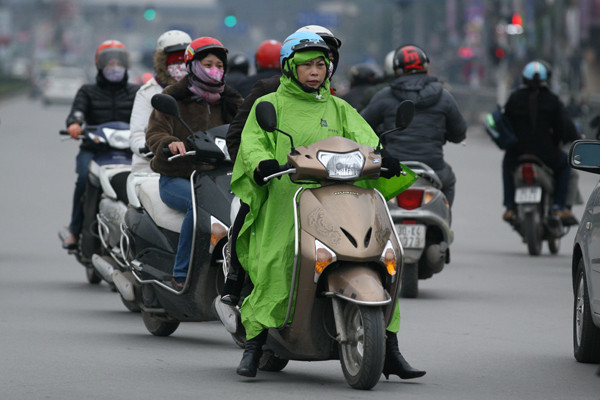 Muốn đi đường không những phải mặc nhiều áo ấm mà còn trùm cả áo mưa để chống rét