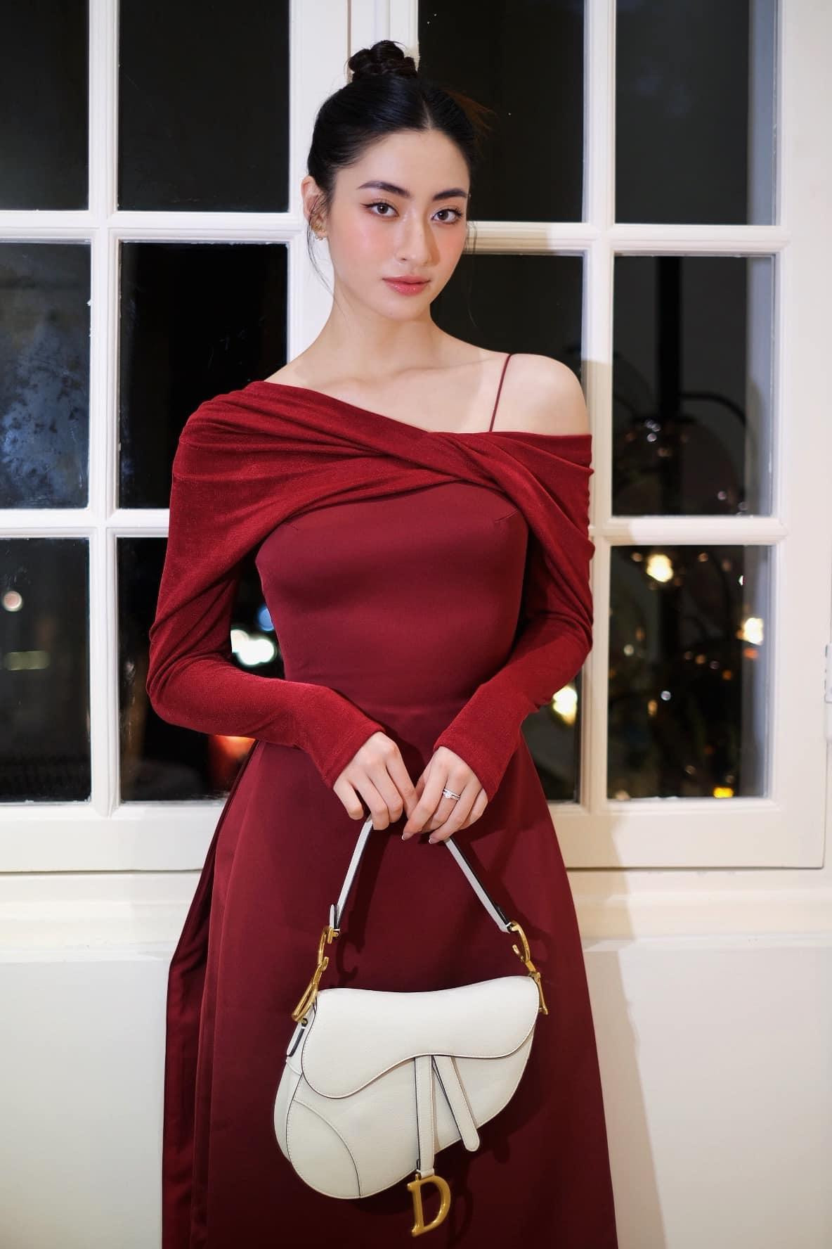 Hoa hậu Lương Thuỳ Linh chọn áo dài cách điệu tông màu đỏ đậm, khoe vai trần quyến rũ.