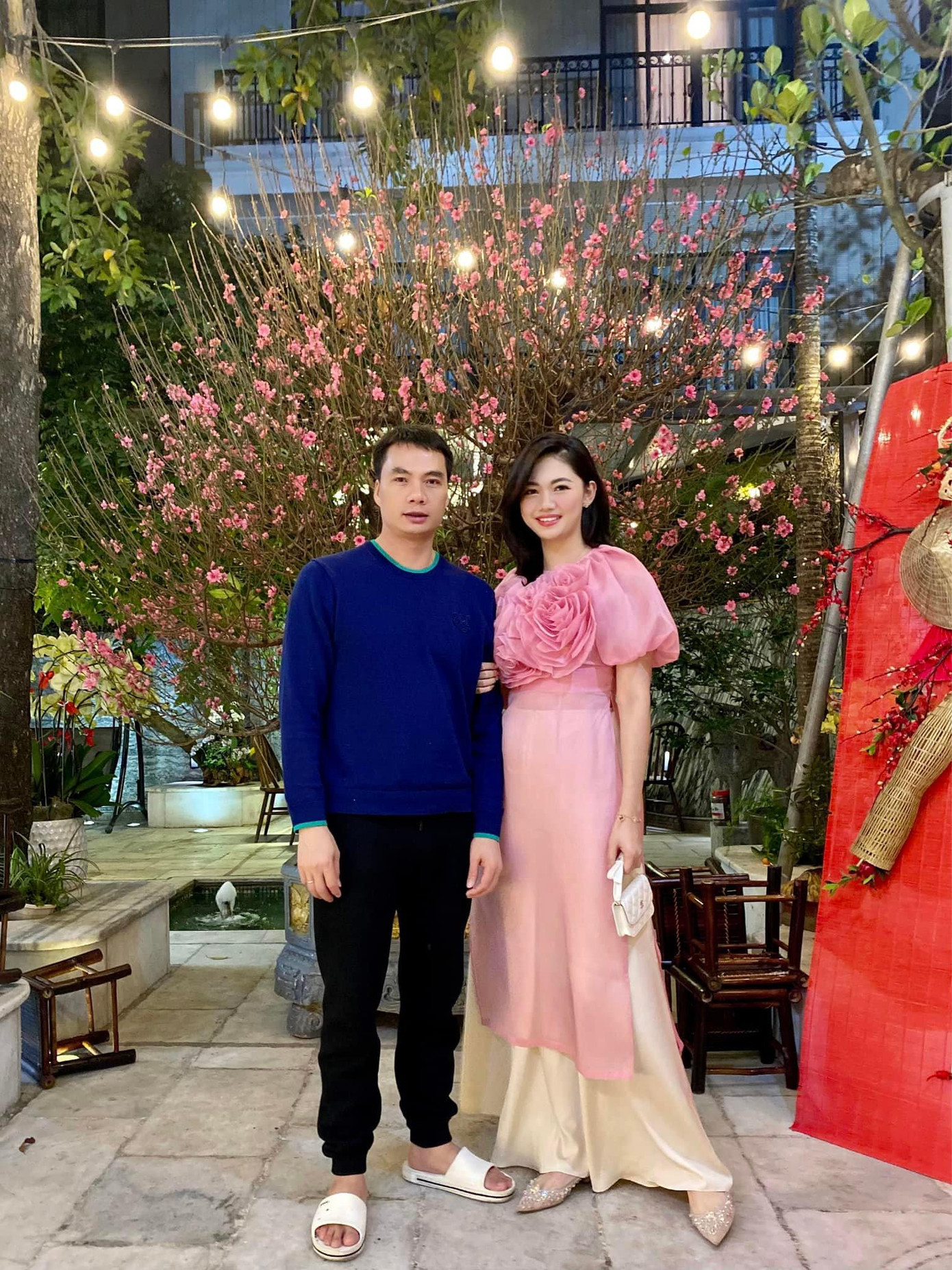 Á hậu Thanh Tú diện áo dài dáng xuông với chi tiết đính hoa cầu kỳ trên ngực áo khi đi du Xuân cùng ông xã trong ngày mùng 1.