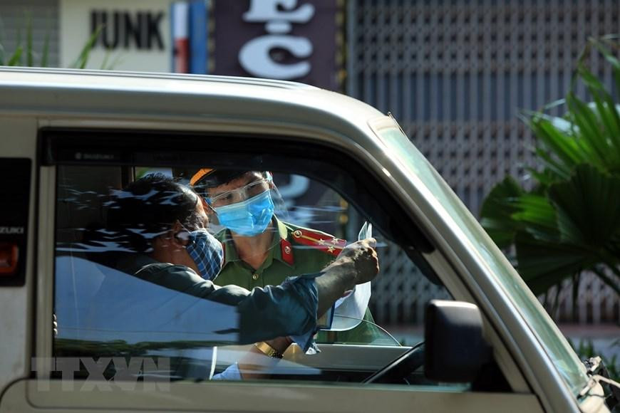 Các lái xe đều phải xuất trình giấy tờ hợp lệ mới được qua chốt kiểm dịch. (Ảnh: Tuấn Anh/TTXVN)