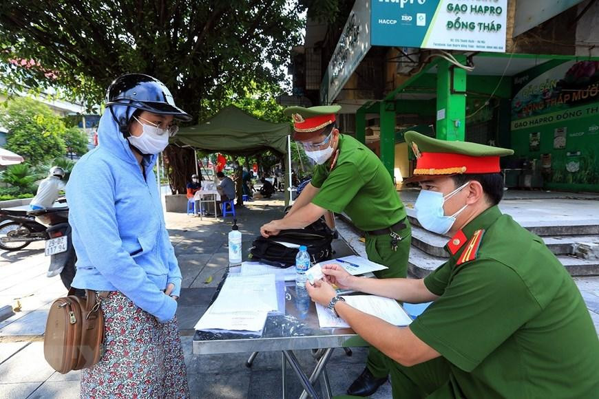 Một trường hợp ra đường không có lý do bị lập biên bản tại chốt kiểm dịch phường Thanh Xuân Bắc. (Ảnh: Tuấn Anh/TTXVN)