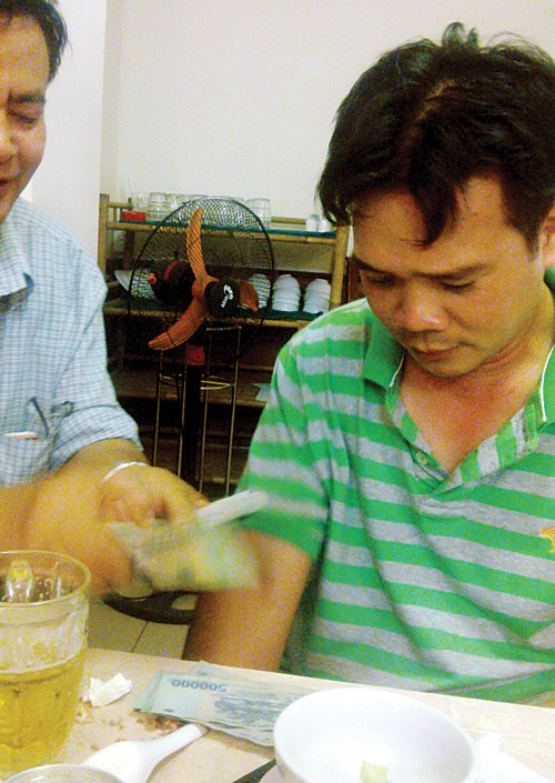 Ông Hoàng đếm tiền giao cho CSGT Huỳnh Minh Đức (phải) - Ảnh: H.K