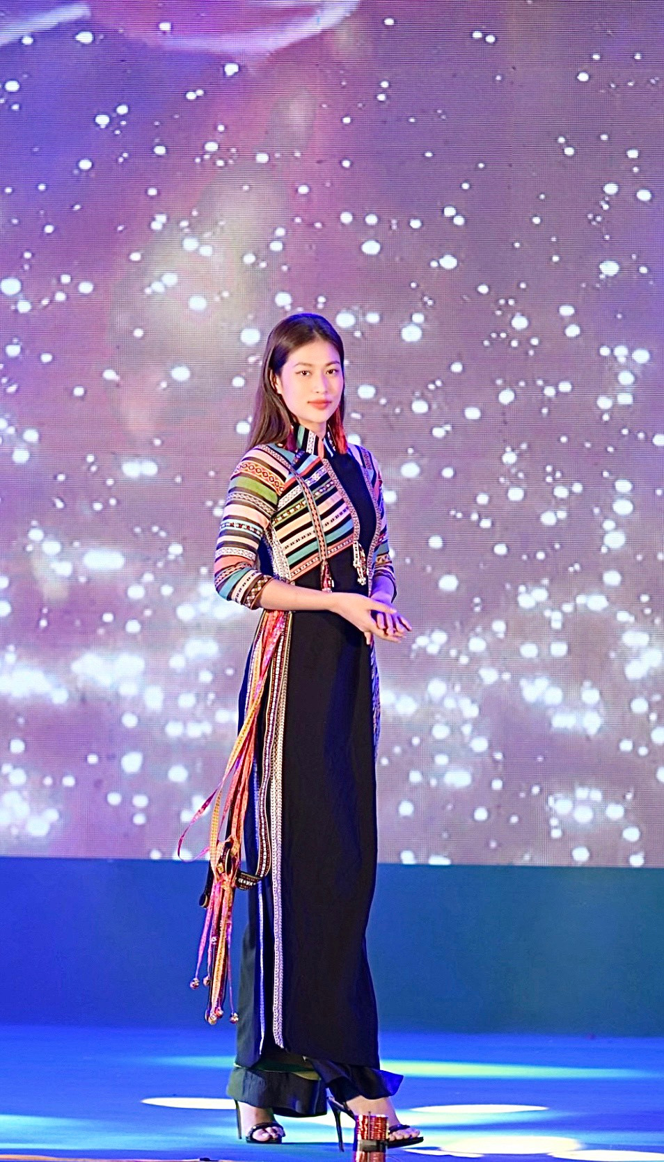 Hoa hậu Thiên Ân trình diễn bộ áo dài với những hoạ tiết được thêu cân xứng ở hai bên vạt áo.