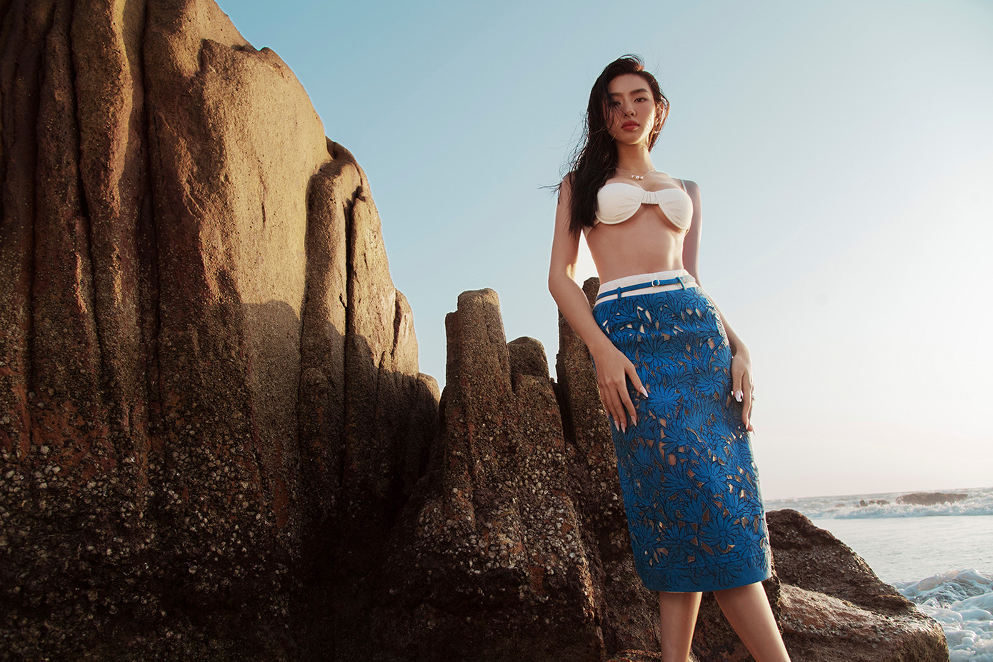 Người đẹp cũng không ngần ngại khoe vóc dáng nóng bỏng trước biển trong những thiết kế táo bạo. Áo ngực màu trắng kết hợp với chân váy ren xuyên thấu tôn lên vẻ đẹp ngọt ngào, sexy của cô.