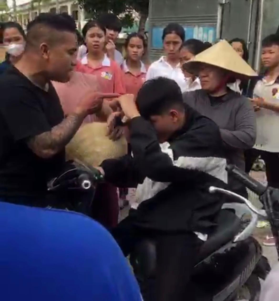 Người đàn ông đánh học sinh trước sự chứng kiến của nhiều người. Ảnh cắt từ video Người đàn ông đánh học sinh trước sự chứng kiến của nhiều người. Ảnh cắt từ video