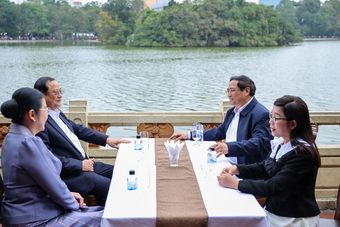 Thủ tướng Phạm Minh Chính và Phu nhân cùng Thủ tướng CHDCND Lào Sonexay Siphandone và Phu nhân uống cà phê trên nhà hàng nằm cạnh hồ Hoàn Kiếm. (Ảnh: Đoàn Bắc)