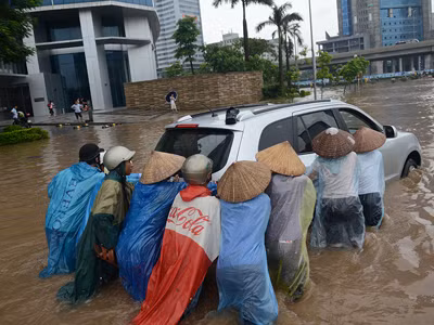 Nhiều người dân được chủ xe thuê với giá 700 nghìn đồng đẩy xe thoát khỏi chỗ ngập. Ảnh: Ngọc Châu. Nhiều người dân được chủ xe thuê với giá 700 nghìn đồng đẩy xe thoát khỏi chỗ ngập. Ảnh: ngọc châu