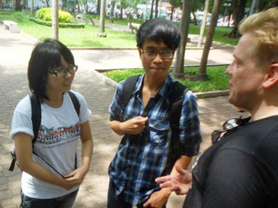 Minh Quang (giữa) cùng thành viên trong CLB tiếng Anh của nhóm trò chuyện với khách du lịch nước ngoài