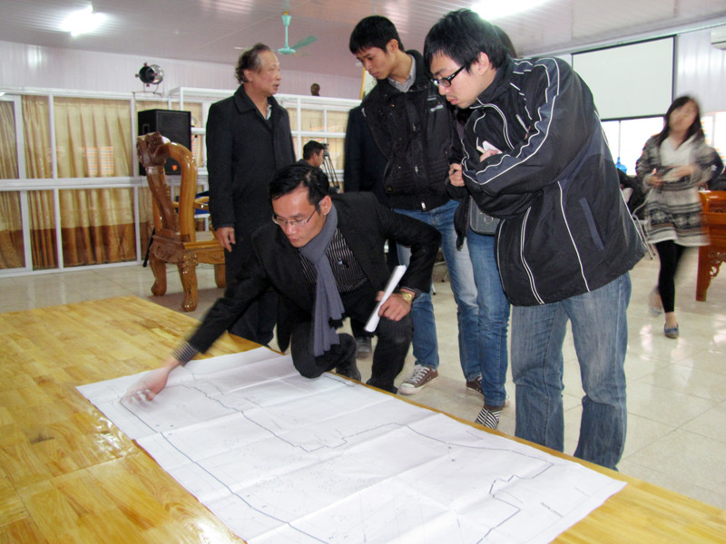 Đại diện công ty chỉ rõ bản quy hoạch dự án và vị trí các ngôi mộ. Ảnh: Tuấn Nguyễn