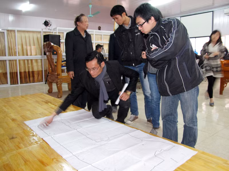 Đại diện công ty chỉ rõ bản quy hoạch dự án và vị trí các ngôi mộ. Ảnh: Tuấn Nguyễn