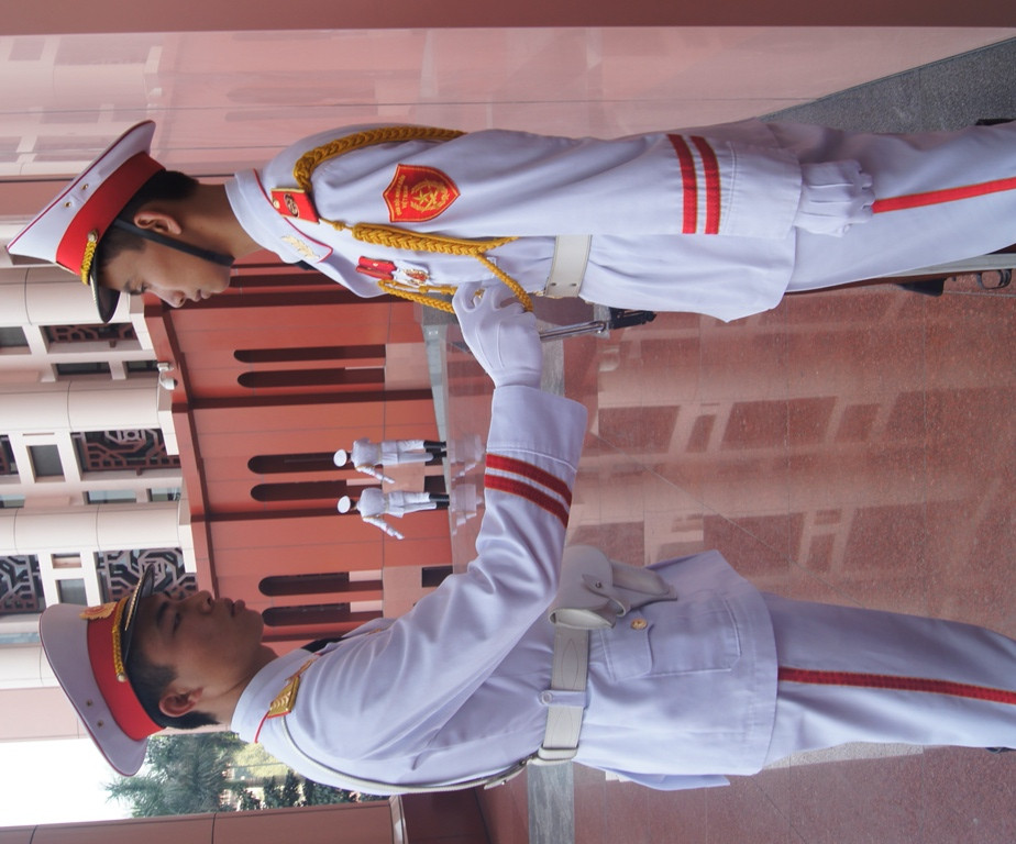 Chỉnh lại trang phục cho đồng đội, đảm bảo đúng lễ tiết tác phong và nghi lễ ngoại giao