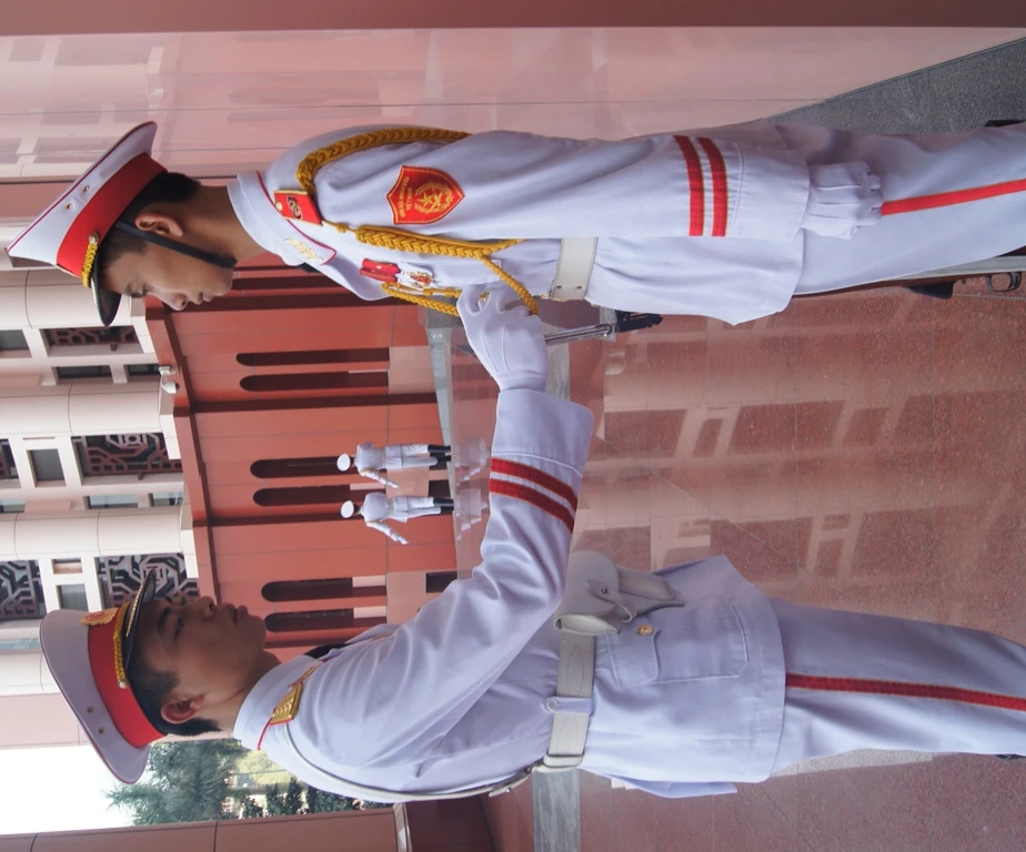 Chỉnh lại trang phục cho đồng đội, đảm bảo đúng lễ tiết tác phong và nghi lễ ngoại giao