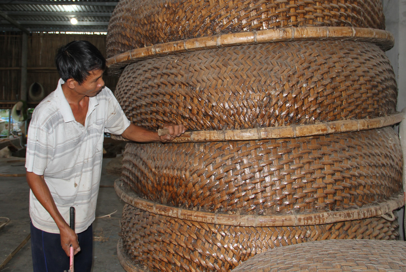 Để làng nghề truyền thống đan thúng chai Phú Mỹ tiếp tục phát triển và mang lại nguồn thu nhập cho người dân, UBND xã An Dân đã vận động bà con thành lập nhóm, tổ hợp sản xuất để đẩy nhanh việc thành lập thương hiệu sản phẩm và có chính sách hỗ trợ bà con làm nghề mở rộng, phát triển sản xuất. Trong ảnh, người dân kiểm tra chất lượng thúng chai trước khi xuất xưởng.