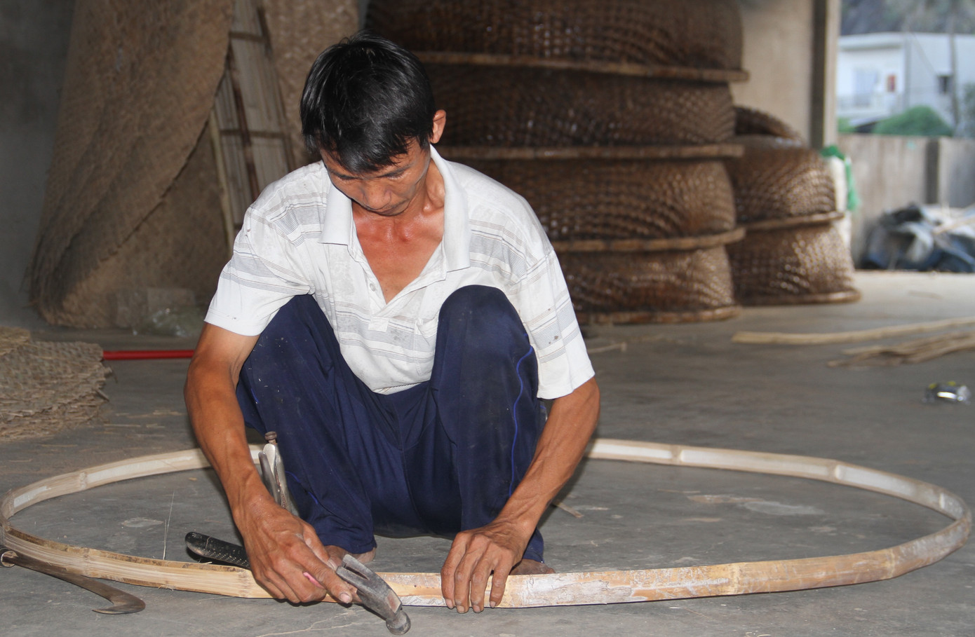 Để làm ra chiếc thúng chai, một người thợ phải đi qua nhiều công đoạn gồm: chẻ tre, vót tre, đan mên, lận, nức và quét dầu. Thợ làm thuyền cần chọn những cây tre có độ tuổi từ một năm đến một năm rưỡi, không được quá non cũng như không quá già, vì như vậy thân thuyền mới có độ bền. Trong ảnh, người dân làng Phú Mỹ nắn vành tre cho thúng chai.