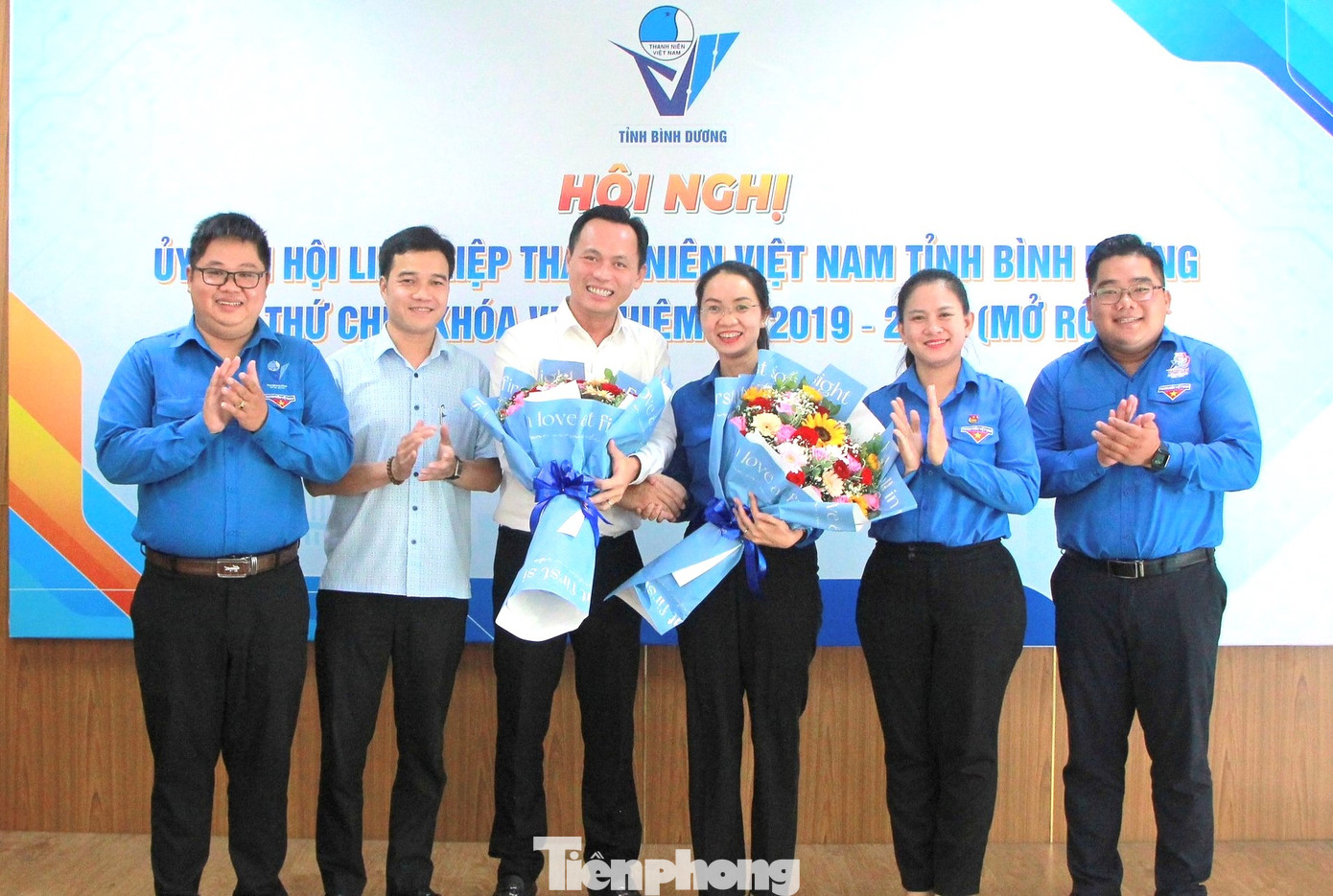 Chị Nguyễn Thanh Thảo (thứ ba từ phải sang) và anh Huỳnh Trần Phi Long (thứ ba từ trái sang) nhận hoa chúc mừng tại hội nghị