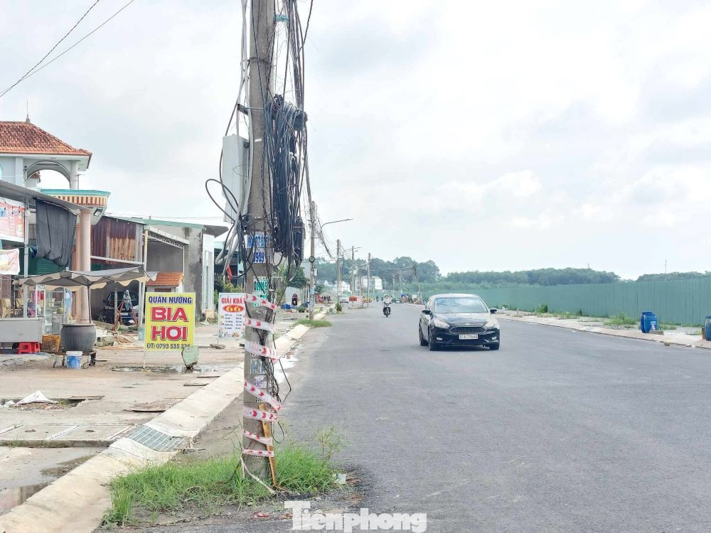 Ghi nhận của phóng viên, tuyến đường ĐX022 nối dài có nhiều trụ điện, dây dẫn điện sinh hoạt chằng chịt đang hiện hữu giữa lòng đường. Nhiều trụ điện bị nghiêng, nguy cơ gãy đổ.