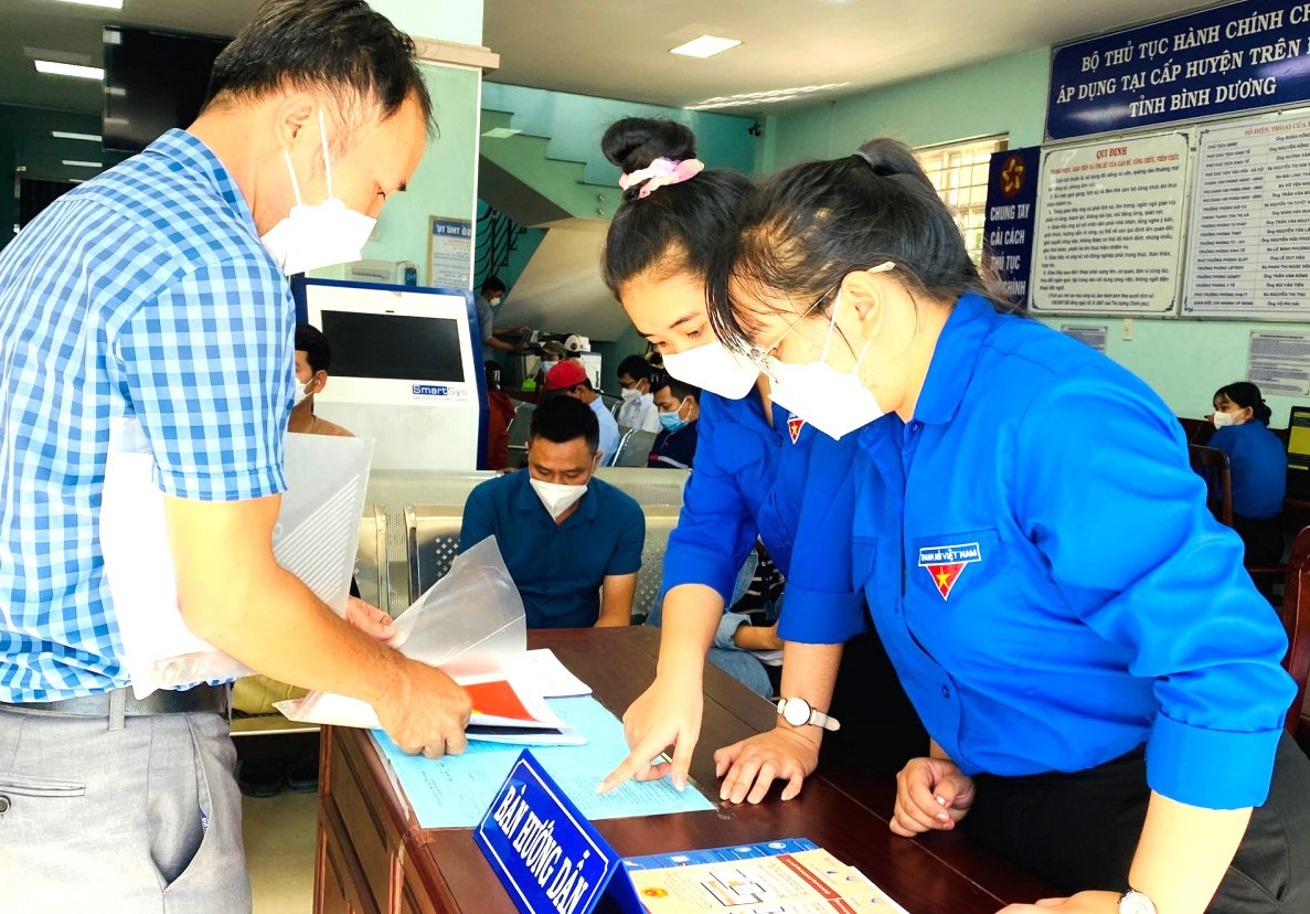 Tình nguyện viên hướng dẫn, hỗ trợ người dân giải quyết thủ tục hành chính tại văn phòng một cửa ở Bình Dương
