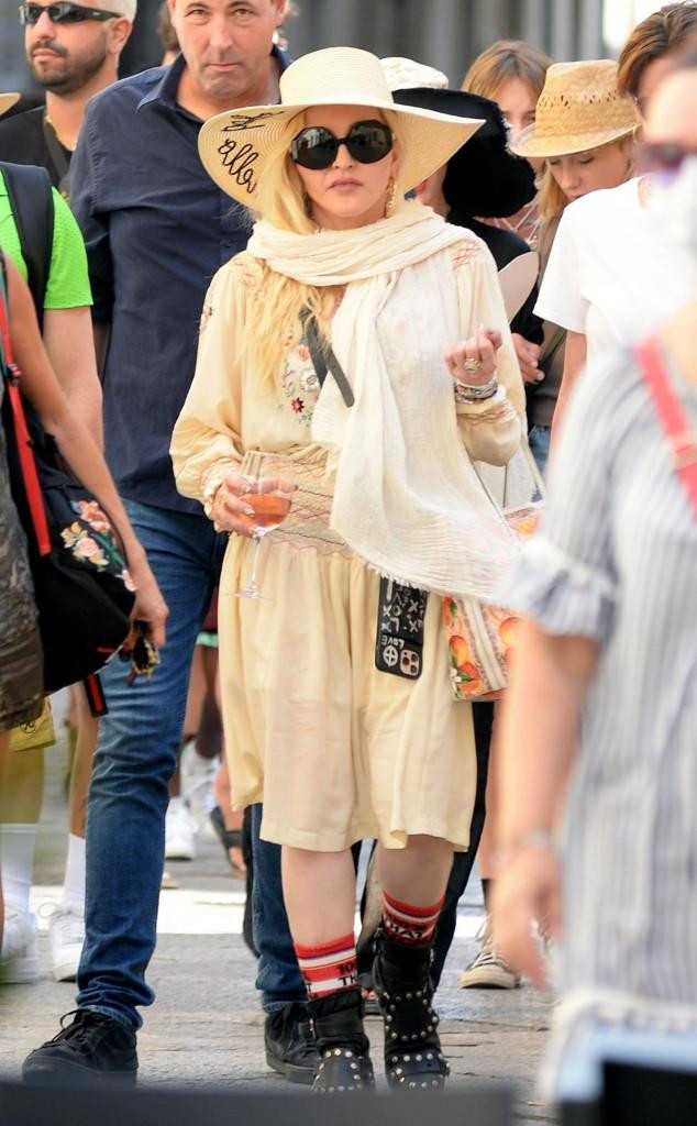 Trong chuyến đi chơi, nữ ca sĩ sinh năm 1958 mặc váy trắng ngà dài qua gối mang phong cách Bohemian, kết hợp boot đen hầm hố, mũ rộng vành, kính râm, nhiều trang sức và túi xách in hình trái cây.