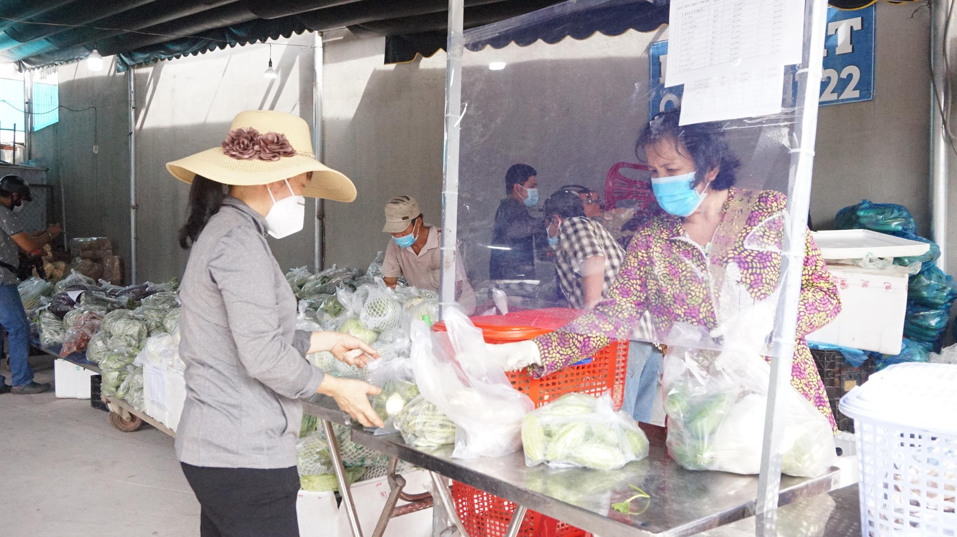 Tiểu thương tại điểm bán chủ động lắp vách ngăn giọt bắn để hạn chế tiếp xúc giữa người bán và người mua.