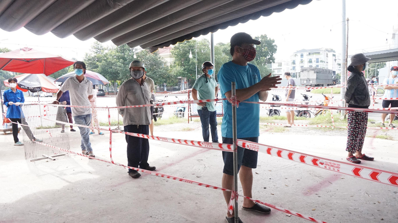 Người dân thực hiện khai báo y tế, giãn cách trước khi vào mua sắm để phòng chống dịch bệnh.