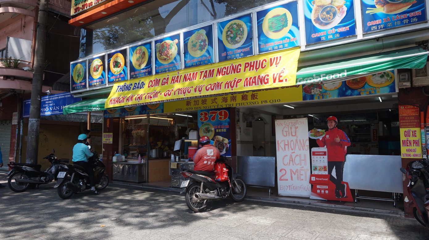 Một quán ăn trên đường Nguyễn Tri Phương (quận 10, TP HCM) treo thông báo &quot;Tạm ngưng phục vụ khách ăn tại tiệm, chỉ bán mang về&quot;.