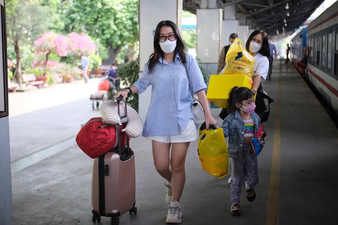 Nhiều người với hành lý lỉnh khỉnh vội vã lên tàu.