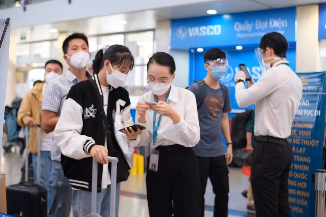 Nhân viên hãng hàng không hướng dẫn hành khách khai báo y tế.