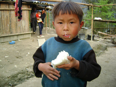 Đứa con thứ 9 của vợ chồng bà Sú hồn nhiên cầm cục cơm trắng ăn ngon lành