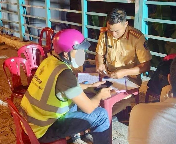 Lực lượng chức năng lập biên bản tài xế dịch vụ vi phạm nồng độ cồn. Ảnh: CA