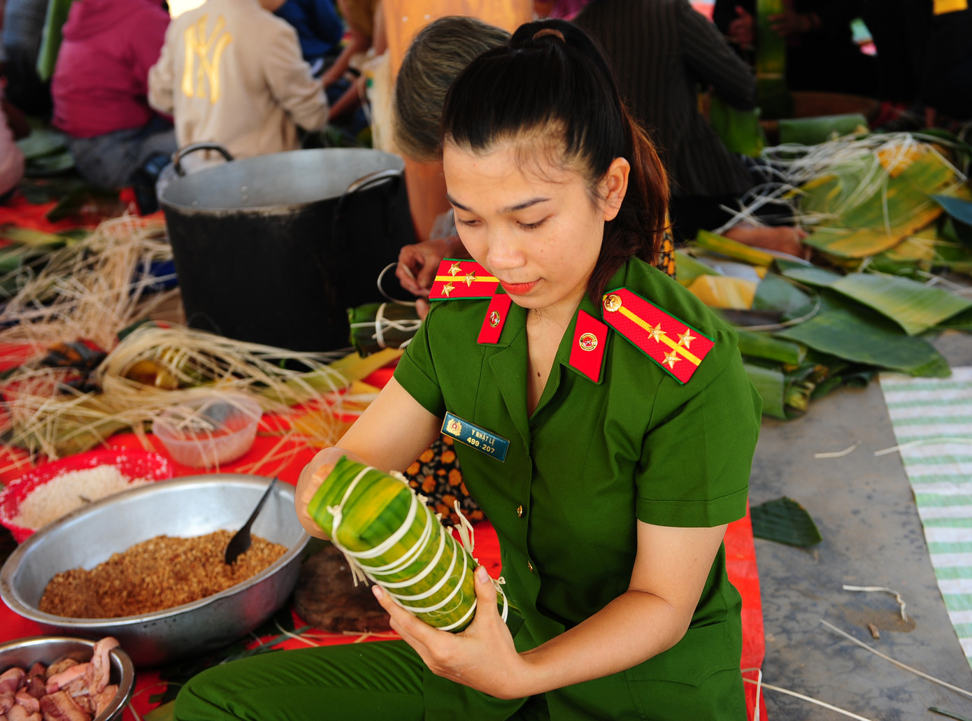 Thượng uý Y Nhật Lệ tích cực tham gia cùng đông đảo người dân gói bánh. Thượng uý Y Nhật Lệ tích cực tham gia cùng đông đảo người dân gói bánh.
