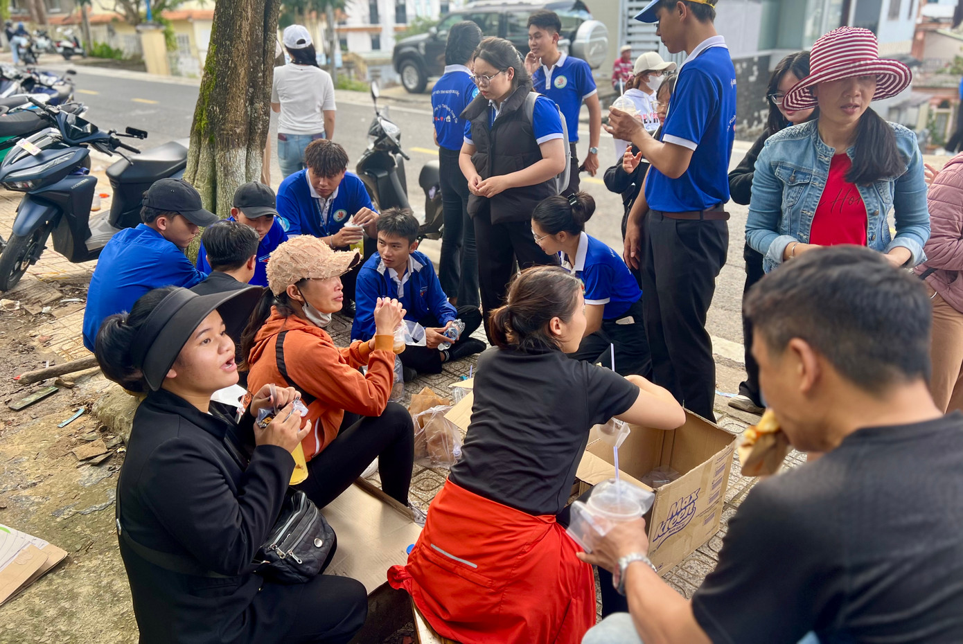 Các tình nguyện viên ăn vội bánh mỳ trước khi xe chở nhu yếu phẩm tới.