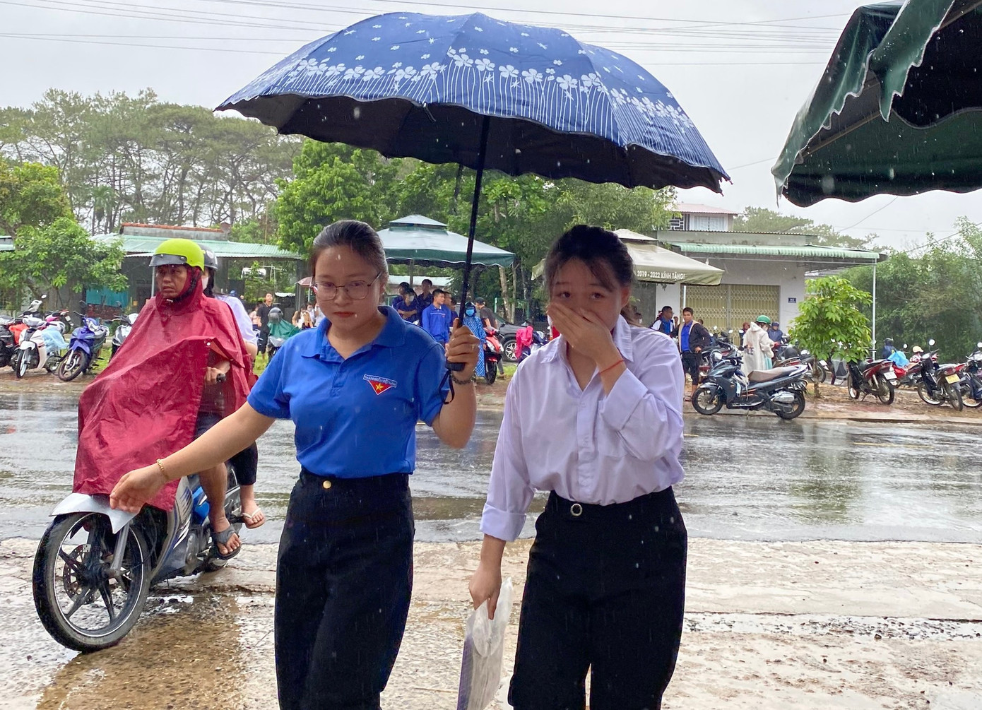 Tình nguyện áo xanh đón ở cổng, che ô cho các thí sinh vào tận phòng thi