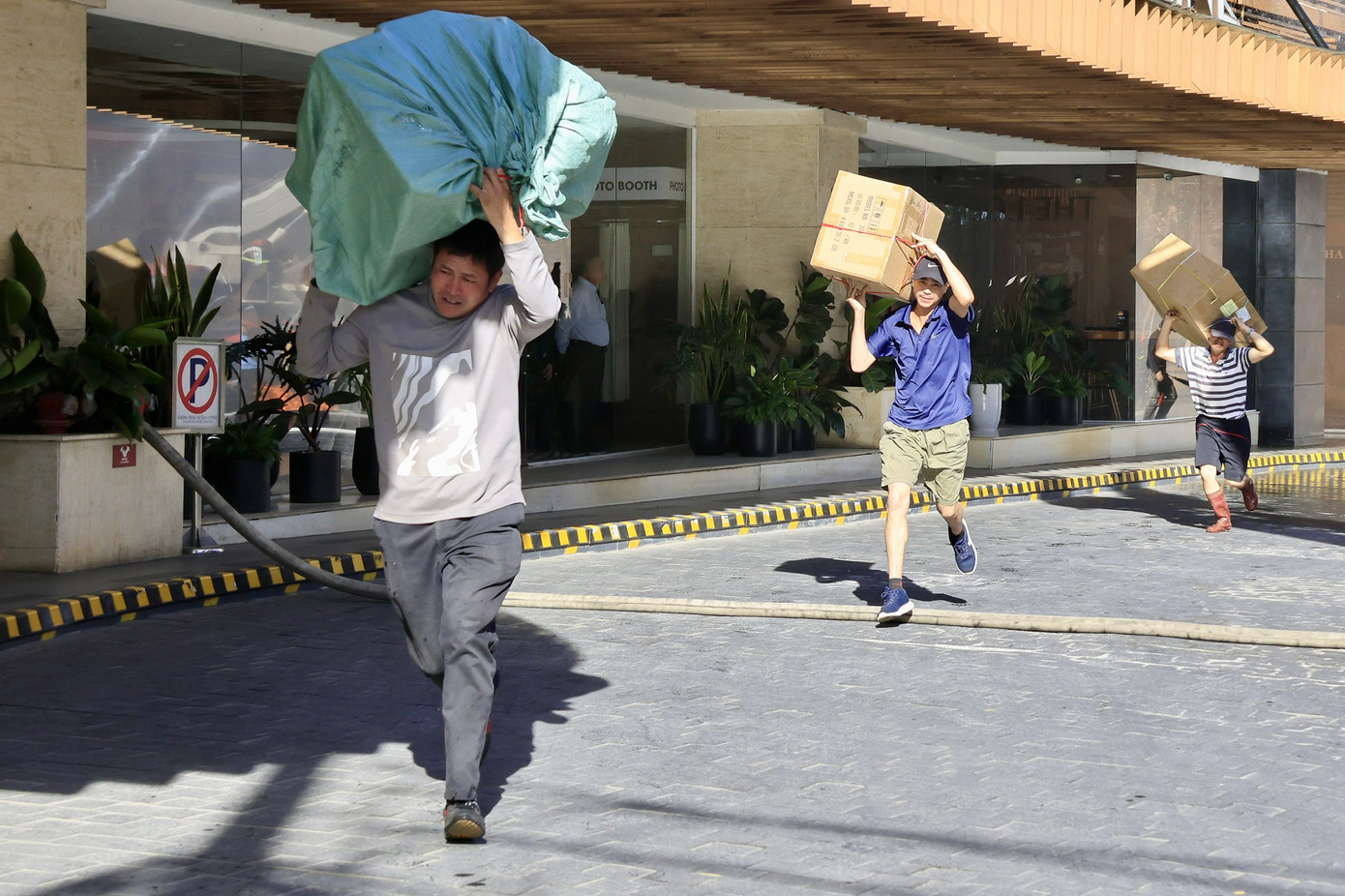 Người dân cùng lực lực lượng chức năng sơ tán hàng hóa ra khỏi đám cháy.