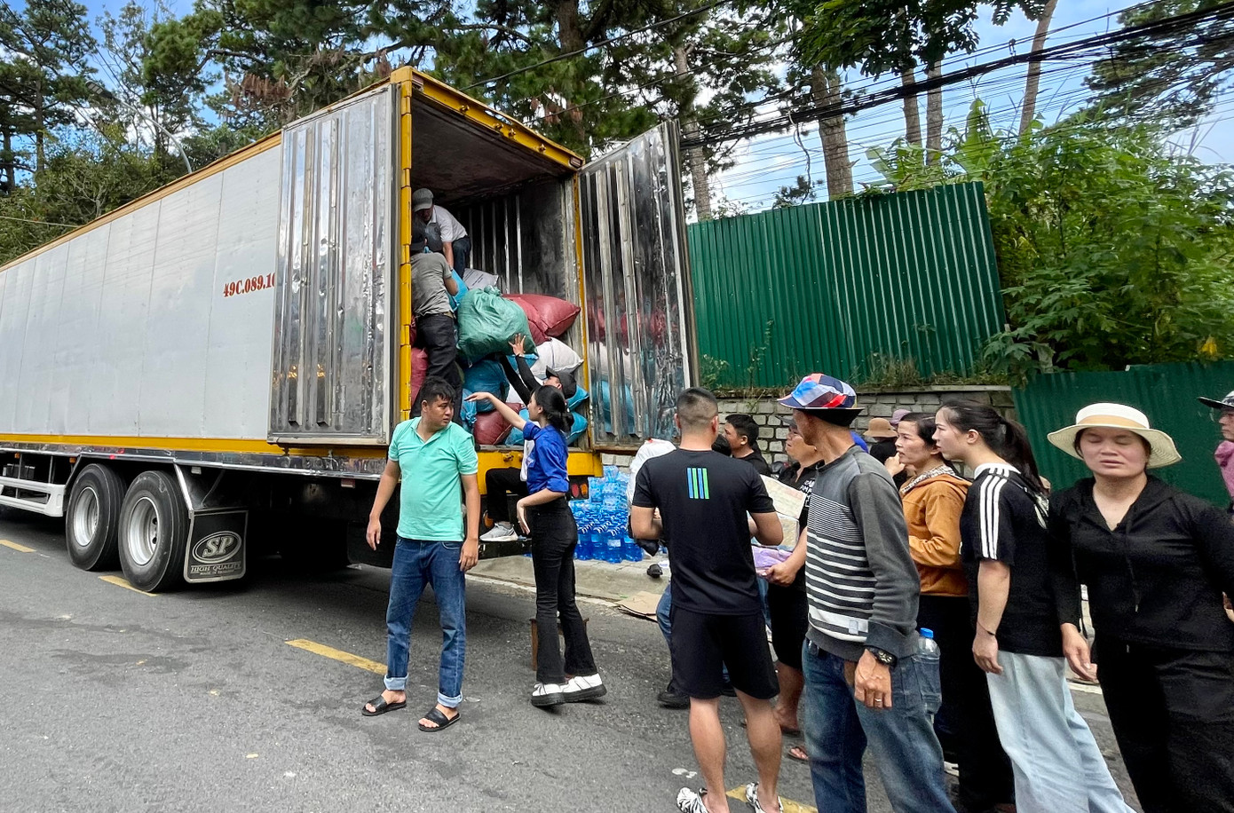 Người dân xếp hàng chuyển các bì chứa nhu yếu phẩm lên xe.