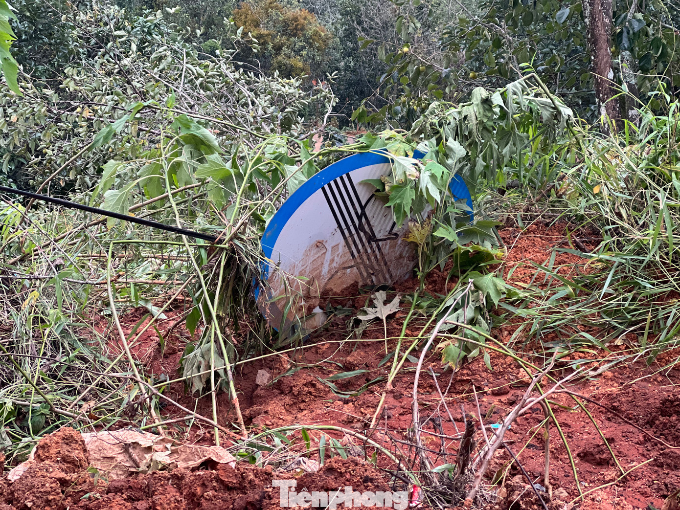 Đất đá cuốn theo 1 biển báo, 1 cột điện xuống vườn của người dân.