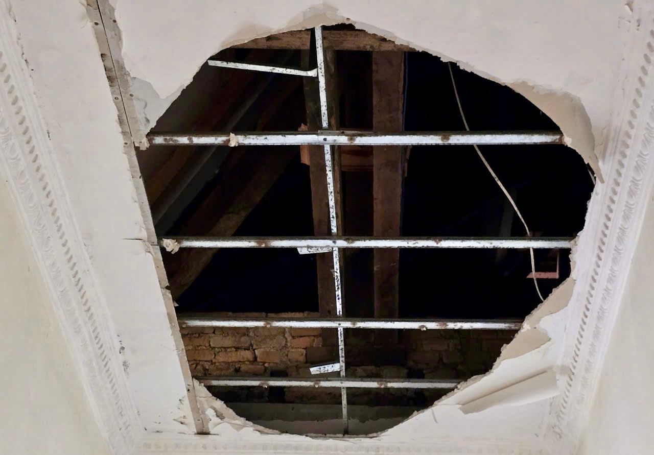 Thạch cao trần nhà rớt xuống từng mảng để lộ cả ngói lợp mái nhà.