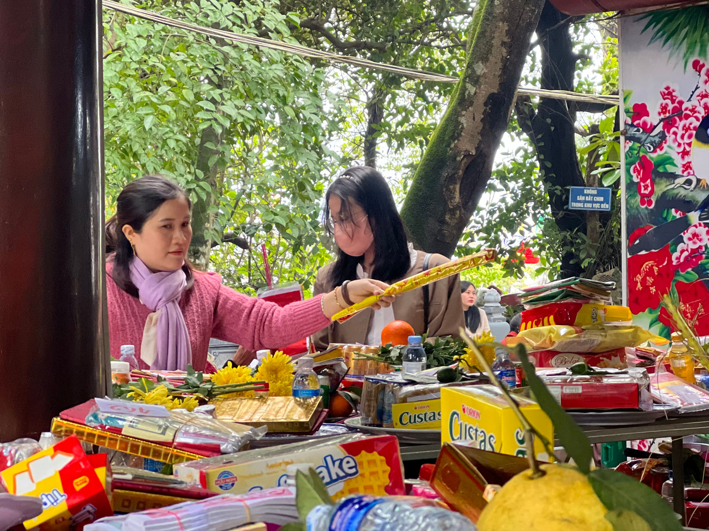 Tại khu vực bày lễ vật, các khay lễ, gồm: bánh kẹo, hoa, quả... chật kín chỗ. Ảnh: Thái Lâm.