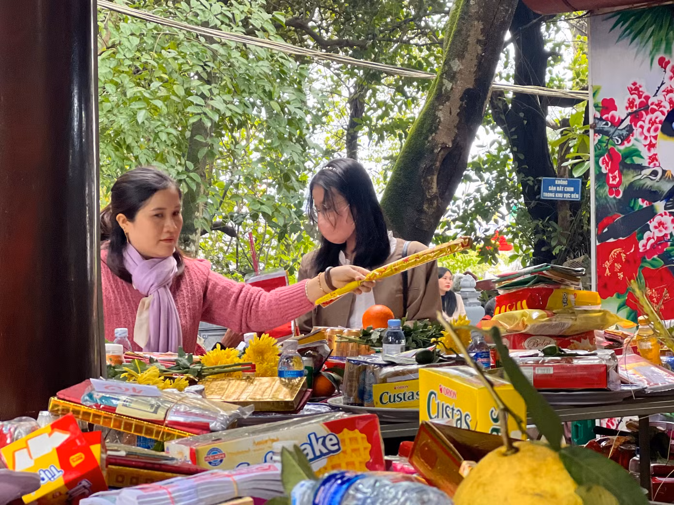 Tại khu vực bày lễ vật, các khay lễ, gồm: bánh kẹo, hoa, quả... chật kín chỗ. Ảnh: Thái Lâm.