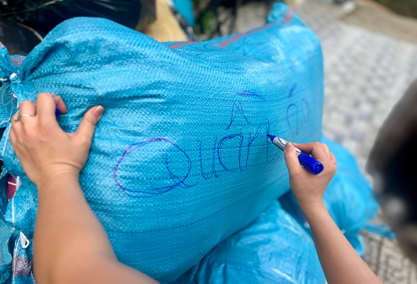 Quần áo được người dân kiểm tra, gói gọn từng túi và ghi tên bên ngoài để nhận biết.