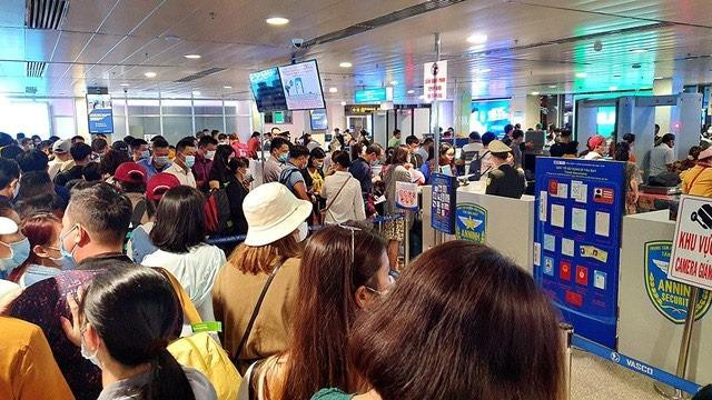 Tại khâu soi chiếu an ninh, nhiều hành khách xếp hàng dài, chen chúc.