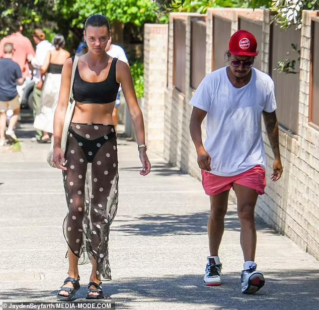 Người đẹp sinh năm 1993 mặc nguyên quần bikini màu đen, áo bra mặc ra ngoài áo bơi và chân váy sheer xuyên thấu táo bạo đi ăn trưa cùng một người bạn.