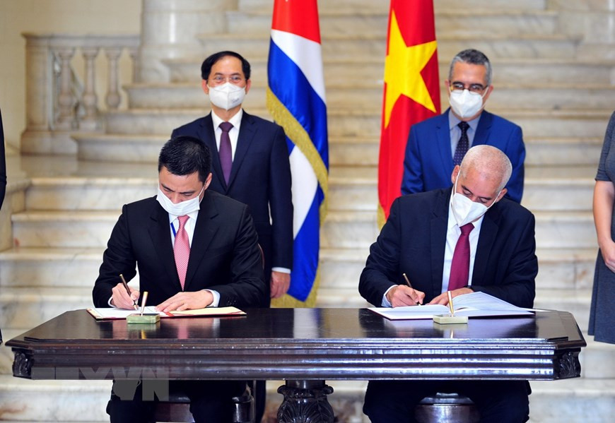 Bộ trưởng Ngoại giao Bùi Thanh Sơn và Quyền Bộ trưởng Ngoại giao Cuba Marcelino Medina chứng kiến Thứ trưởng Ngoại giao Đặng Hoàng Giang và Thứ trưởng Ngoại giao Gerardo Penalver ký Bản ghi nhớ hợp tác giữa Học viện Ngoại giao Việt Nam và Học viện Quan hệ quốc tế Raul Roa Garcia của Cuba (2021). (Ảnh: TTXVN).