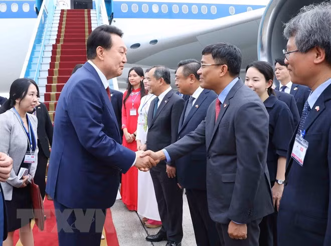 Thứ trưởng Ngoại giao Nguyễn Minh Vũ đón Tổng thống Hàn Quốc Yoon Suk Yeol và Phu nhân tại sân bay quốc tế Nội Bài. Ảnh: TTXVN.