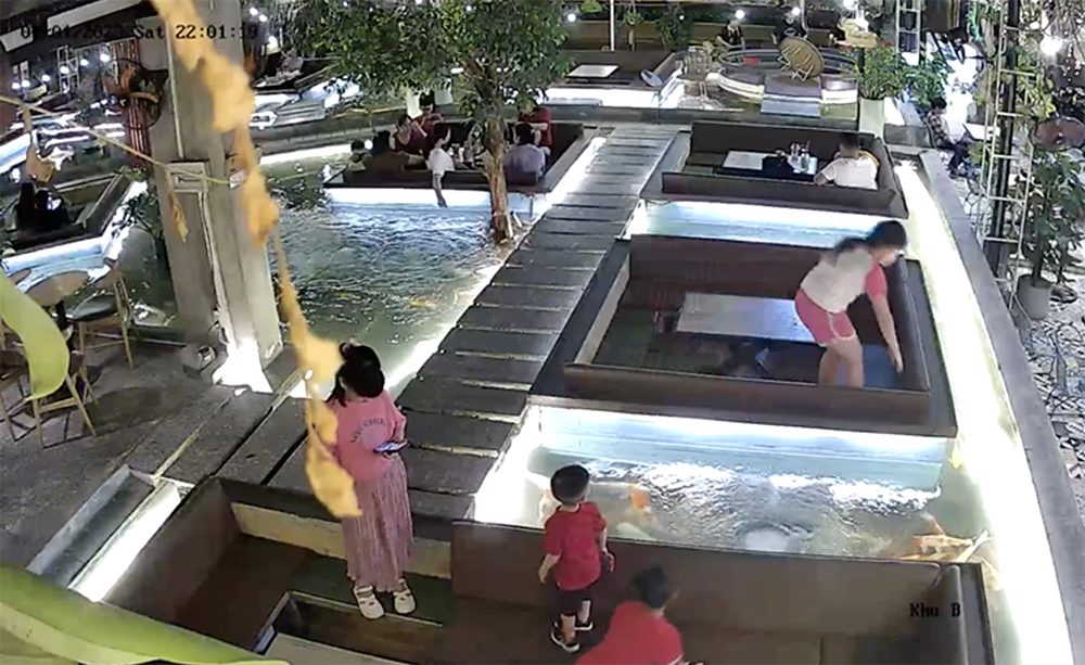 Camera an ninh trong quán ghi nhận bé gái chừng 10 tuổi nhặt ví tiền của khách để quên mang về bàn của mình. Ảnh: Cắt từ clip. Camera an ninh trong quán ghi nhận bé gái chừng 10 tuổi nhặt ví tiền của khách để quên mang về bàn của mình. Ảnh: Cắt từ clip.