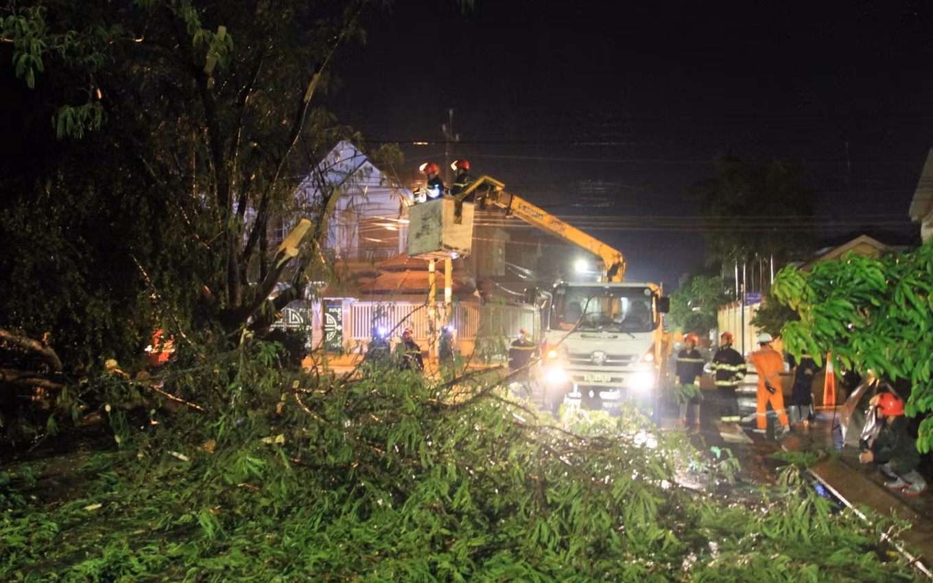 Các chiến sĩ công an phối hợp cùng điện lực cắt tỉa cành cây bị gãy (Ảnh: V.T.).