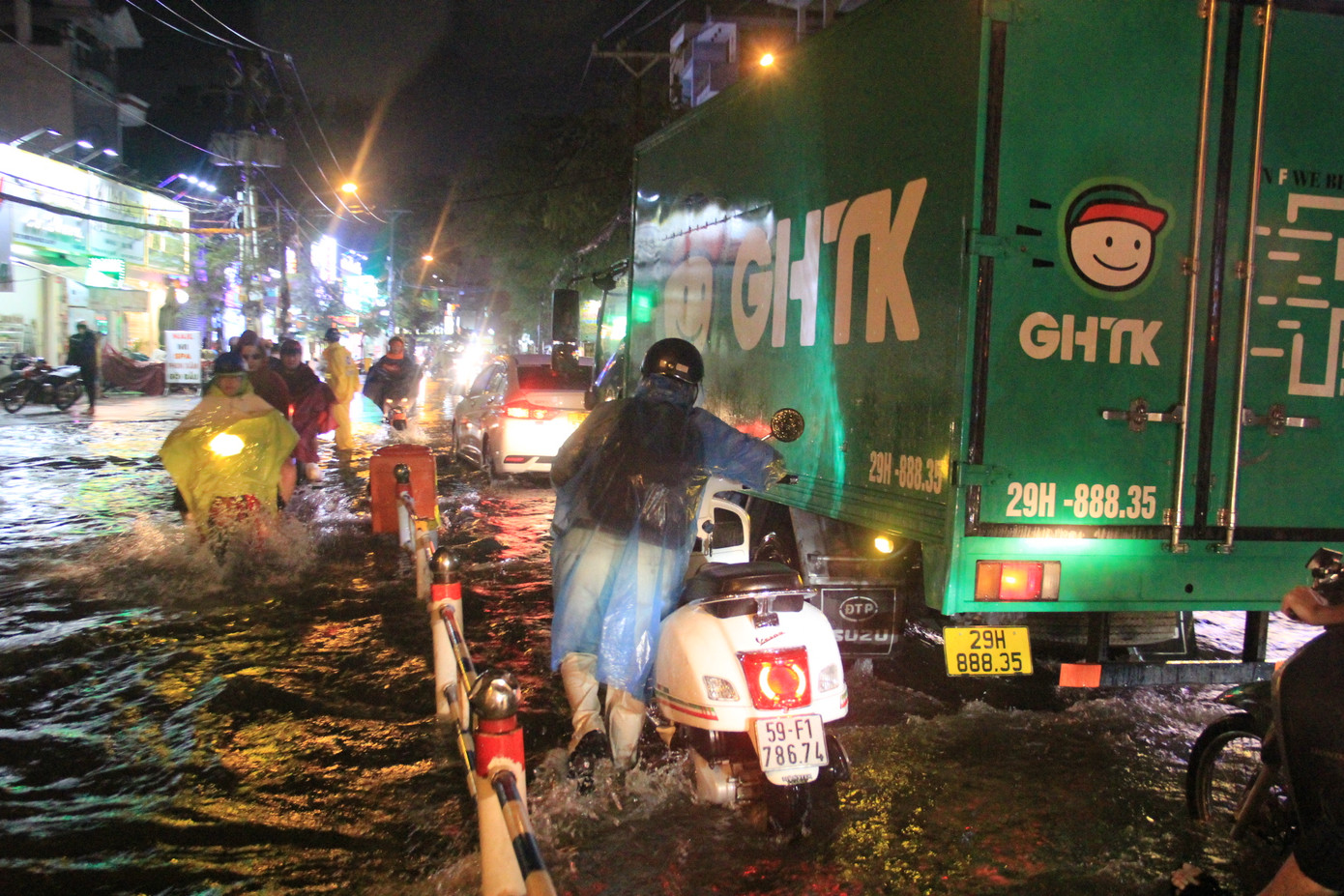 Người dân phải bì bõm lội nước đưa phương tiện thoát khỏi điểm ngập.