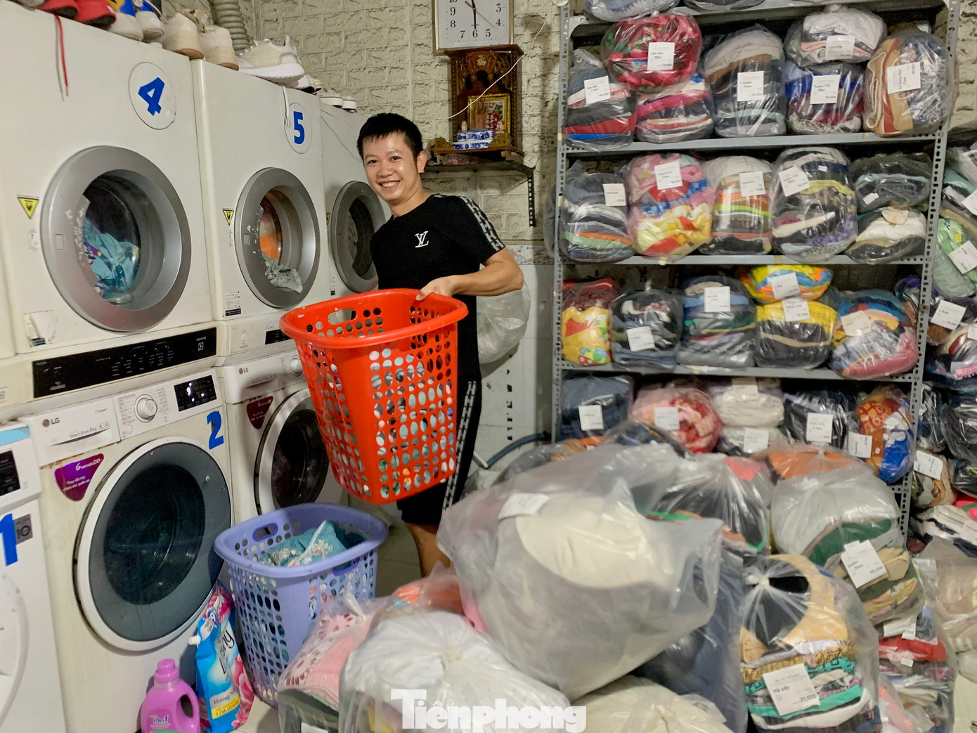 Anh Hưng làm việc không ngơi tay với đống quần áo cao đến nửa người. Ảnh: Nhật Xuân