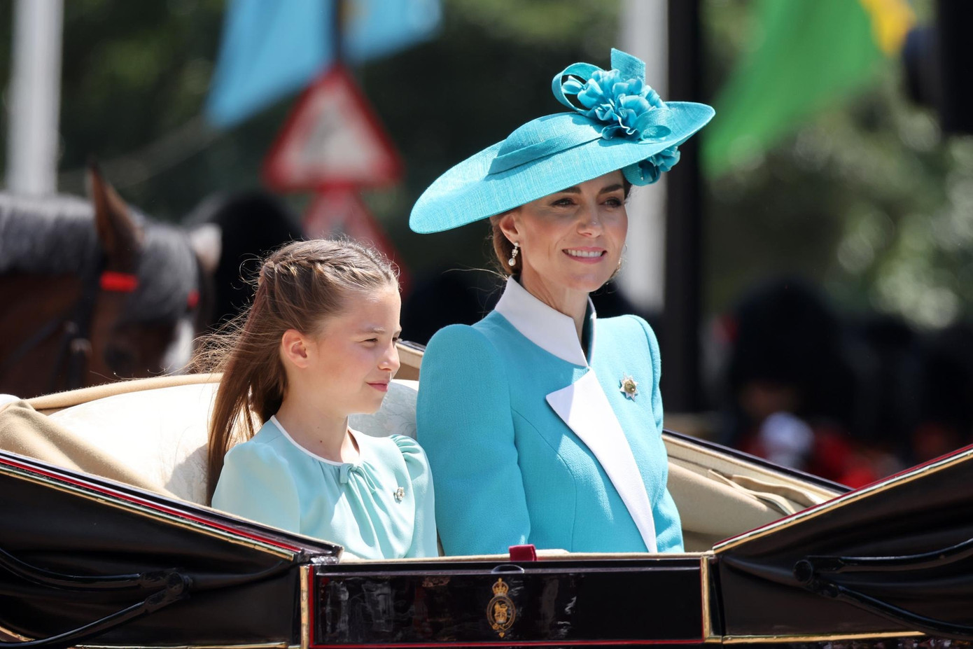 Công chúa Charlotte cũng mặc váy màu xanh giống mẹ, với kiểu tóc tết nửa buộc, nửa thả. Cô bé mang theo chiếc trâm cài hình móng ngựa bằng kim cương do cố Nữ hoàng Elizabeth tặng. Hoàng tử George và Louis diện Âu phục kiểu cổ điển với cà vạt màu đỏ. Ảnh: Getty Images.